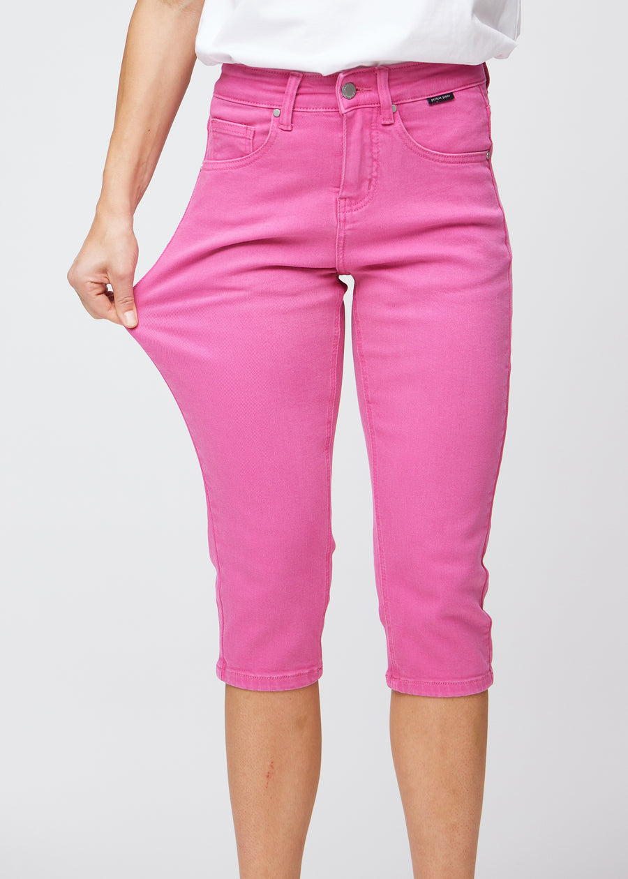 Model strækker caprisene ved låret for at vise det bløde og fleksible stretch.