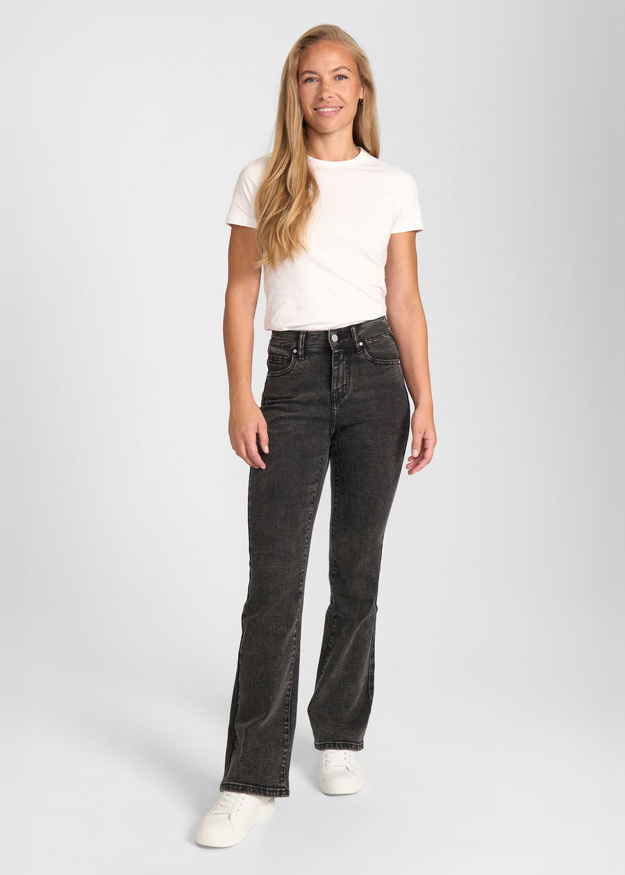 Model går ind i billedet, strækker i jeansene, viser dem frem ved at dreje rundt, og forlader derefter billedet.