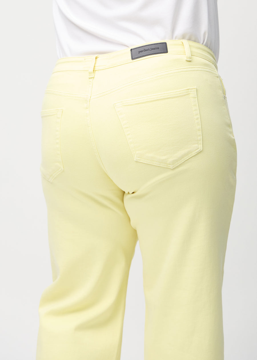 Lysegule loose jeans set bagfra tæt på en plus-size model for at vise detaljer.
