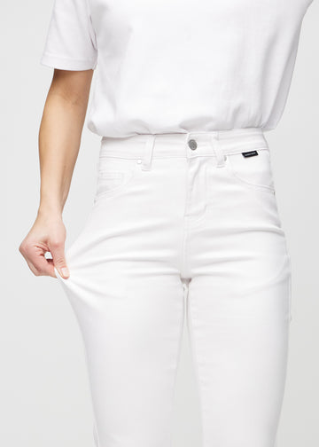 Model strækker jeansene ved låret for at vise stretch.