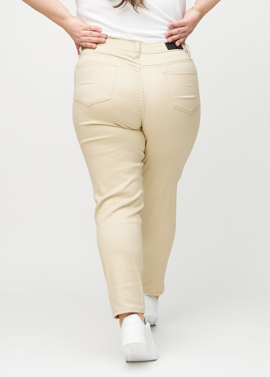 Beige slim jeans set bagfra på en plus-size model, så man kan se hele produktet.