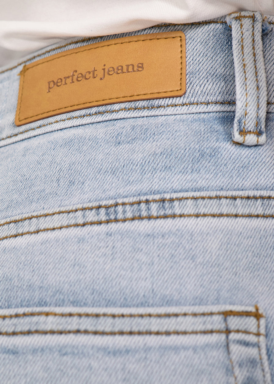 Nærbillede af lyseblå denim med Perfect Jeans læderpatch bagpå i taljen.