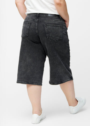Løse, mørkegrå denim capris i farven Shadows set bagfra på plus-size model, så pasform og længde kan ses.