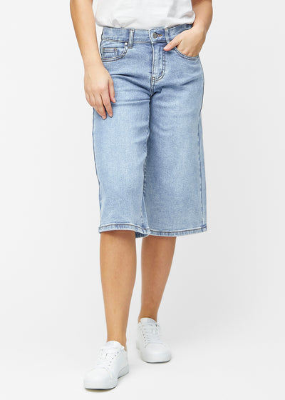 Loose, light blue denim capris in the colour Waves, sitting at the hips and falling loosely over the thighs to just below the knee, seen from the front.