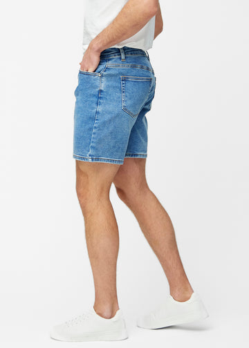 Blue denim shorts for men in the colour Rivers with a regular fit seen from the side on a model.