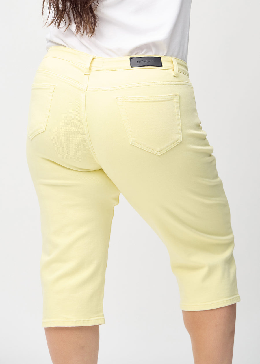 Light yellow regular capris seen from the back close up on a plus-size model to show details.