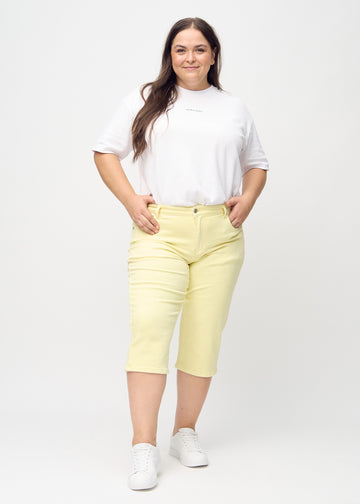 Full-length photo of a model wearing light yellow Regular capris in the color Lemonades.