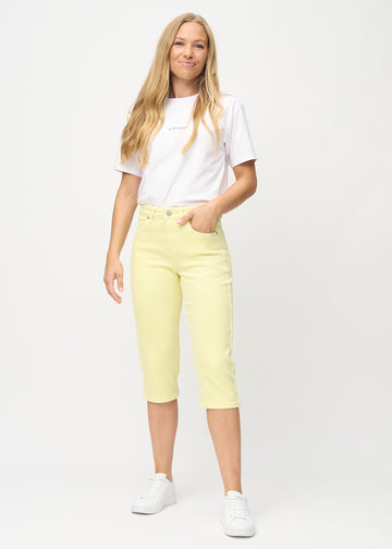 Full-length photo of a model wearing light yellow Regular capris in the color Lemonades.