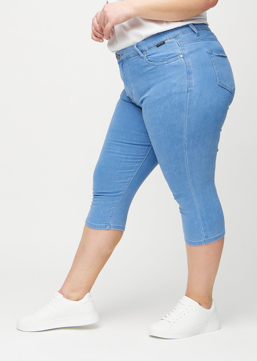 Skinny capris for women in blue fabric, color Geraniums. Side view on a plus-size model, showing the fitted cut.