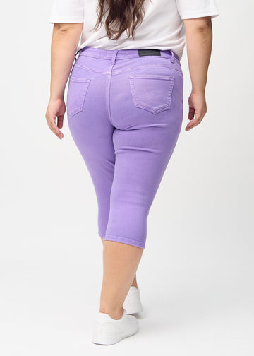 Skinny capris for women in pastel purple fabric, color Lavenders. Back view on a plus-size model, showing the fit and back pockets.