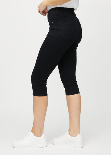 Skinny capris for women in black fabric, color Ravens. Side view on a model, showing the fitted cut.