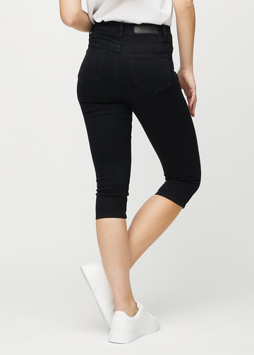 Skinny capris for women in black fabric, color Ravens. Back view on a model, showing the fit and back pockets.