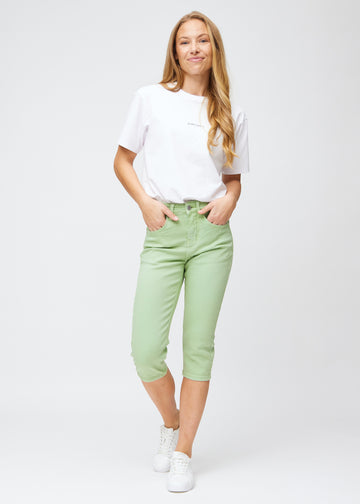 Slim capris for women in pastel light green jeans fabric, color Mints. Full-length view of a model wearing slim capris.