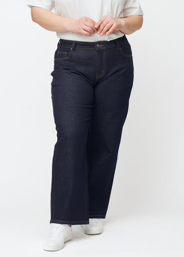 Deep dark blue denim jeans for women in the color Midnights with a loose fit, shown from the front on a plus-size model.
