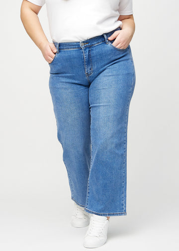 Loose jeans for women in blue, color Rivers. Front view on a plus-size model, showing the roomy, wide-leg fit.