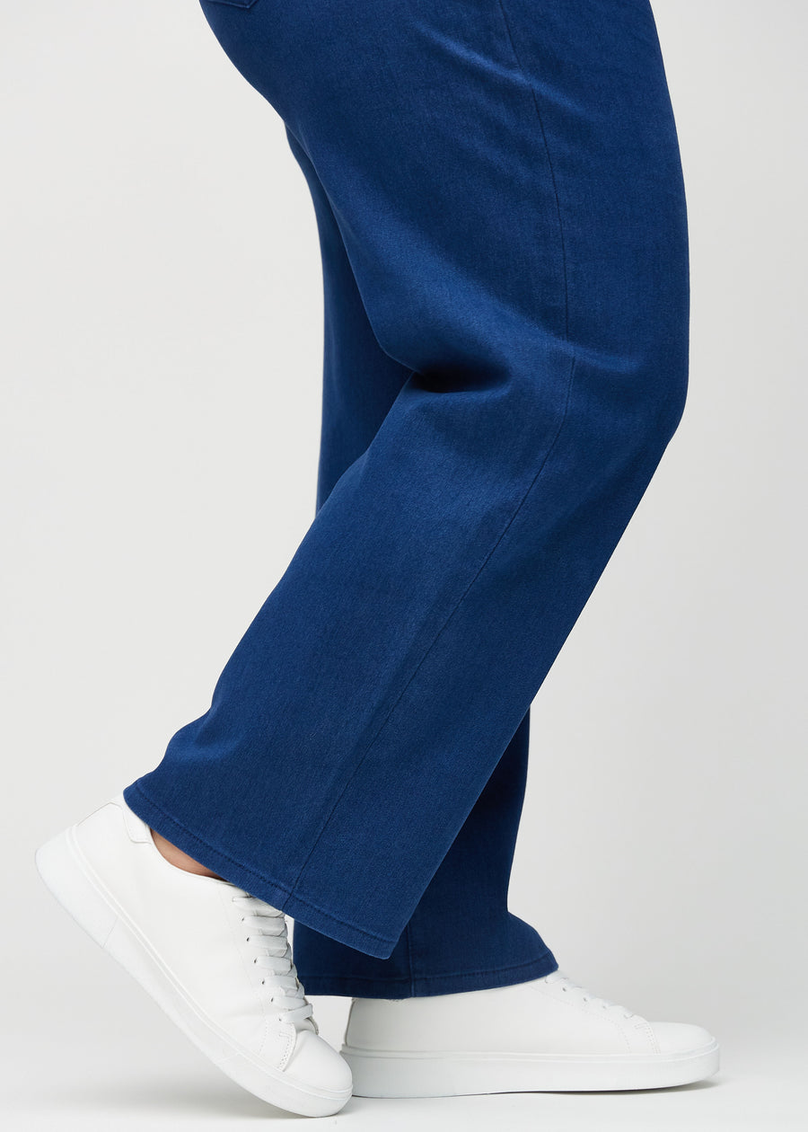 Loose jeans for women in dark blue, color Royals. Close-up at the ankles on a plus-size model, showing the wide leg openings.