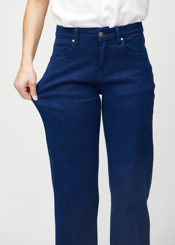 Loose jeans for women in dark blue, color Royals. A model stretches the denim at the thigh to show the fabric&