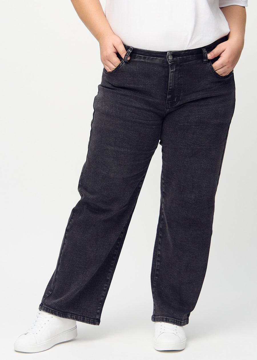 Loose jeans for women in dark grey, color Shadows. Front view on a plus-size model, showing the roomy, wide-leg fit.