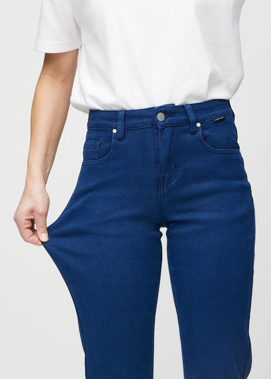 Regular jeans for women in dark blue, color Royals. A model stretches the fabric at the thigh to show its stretch.