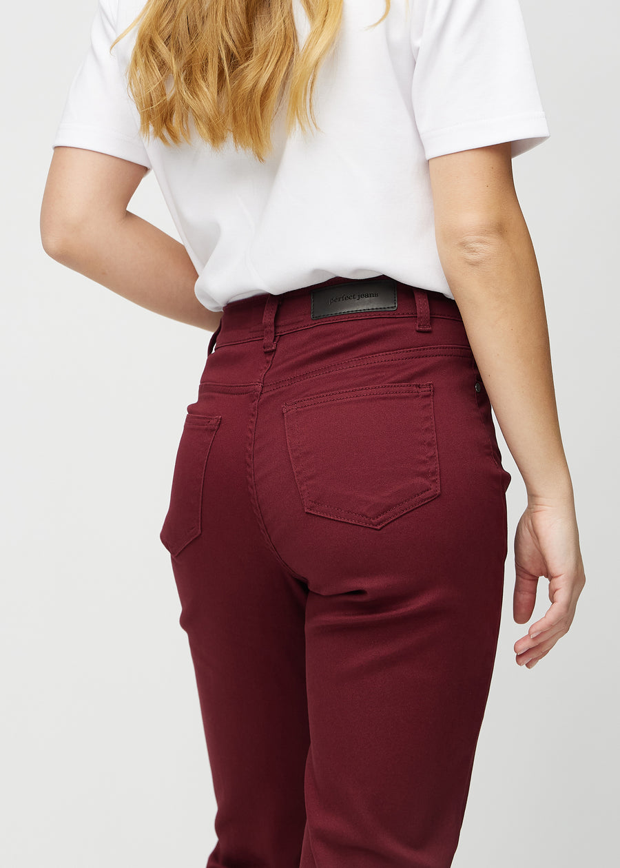 Regular jeans for women in dark red, color Santas. Close-up from behind on a model, showing fit and details.
