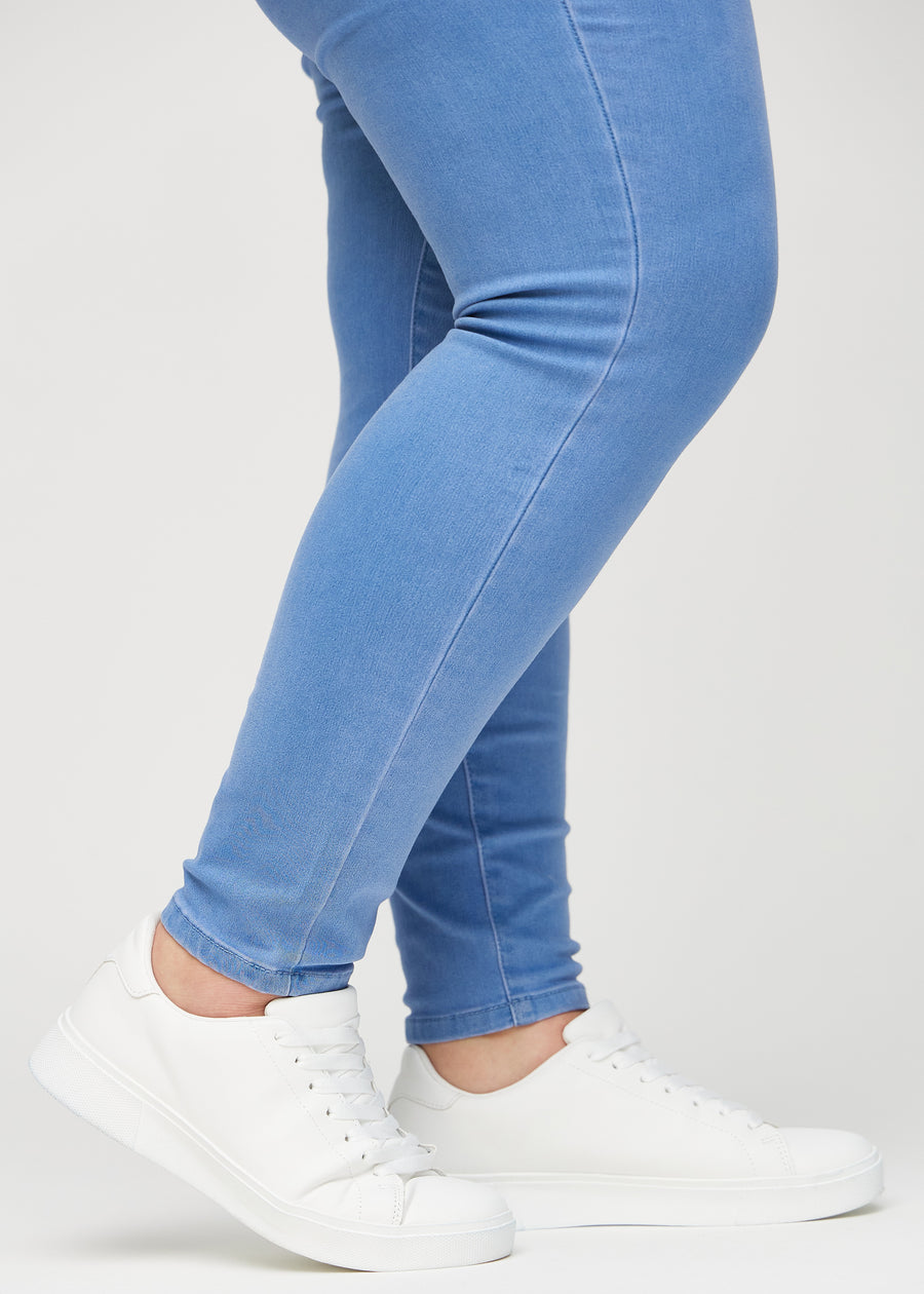 The ankles of a plus-size model, so you can see how tightly the jeans fit.