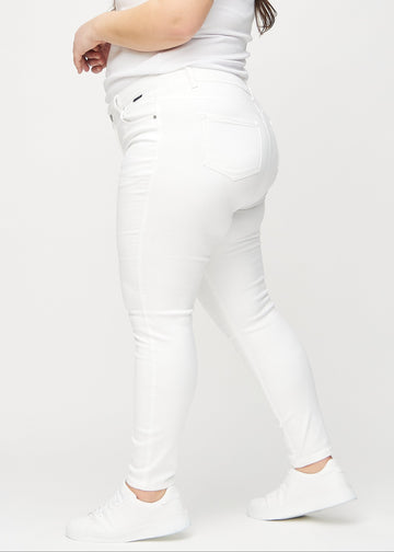 Skinny jeans for women in white, color Marguerites. Side view on a plus-size model.