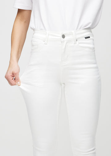 Skinny jeans for women in white, color Marguerites. A model stretches the jeans at the thigh to show the fabric&