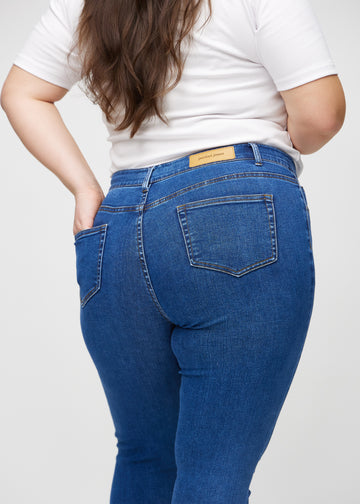 Skinny jeans for women in dark blue, color Oceans. Close-up back view on a plus-size model, showing details.