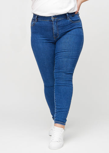 Skinny jeans for women in dark blue, color Oceans. Front view on a plus-size model, showing the close fit through the legs.