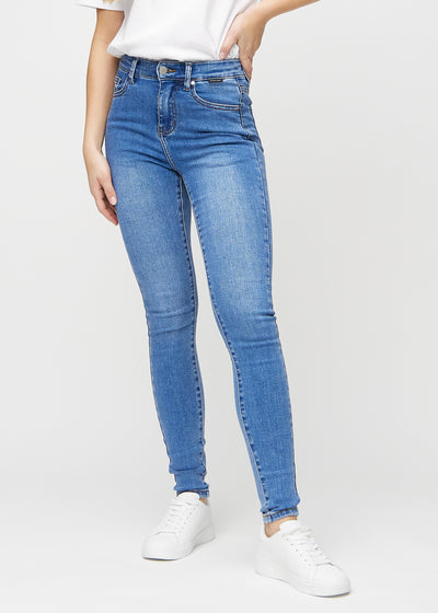 Skinny jeans for women in blue, color Rivers. Front view on a model, showing the close fit through the legs.