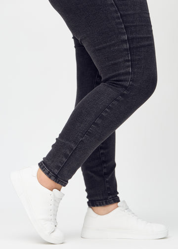 The ankles of a plus-size model, so you can see how closely the jeans fit.