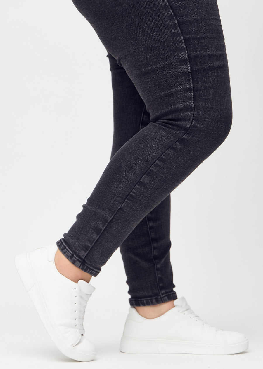 The ankles of a plus-size model, so you can see how closely the jeans fit.