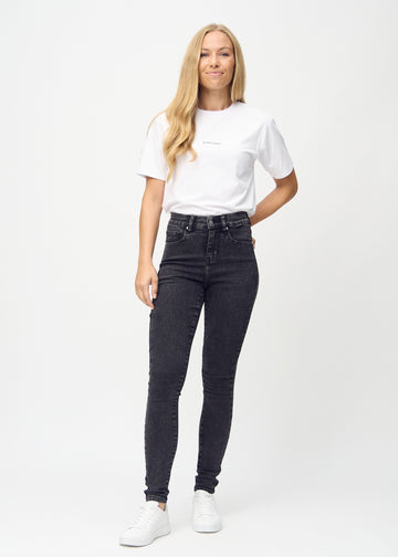 Full image of model in dark grey denim skinny jeans.