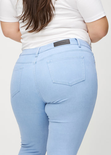 Skinny jeans for women in light blue, color Skies. Close-up back view on a plus-size model, showing the details.