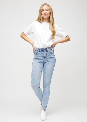 Skinny jeans for women in light blue, color Waves. Full-length view of a model in the jeans.