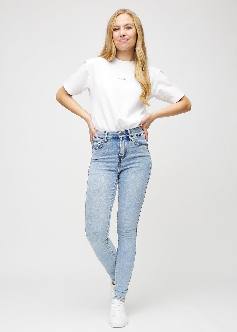 Skinny jeans for women in light blue, color Waves. Full-length view of a model in the jeans.