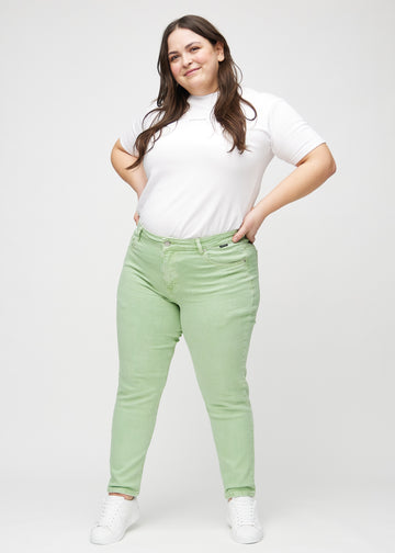 Slim jeans for women in light green, color Mints. Full-length view of a plus-size model wearing the jeans.