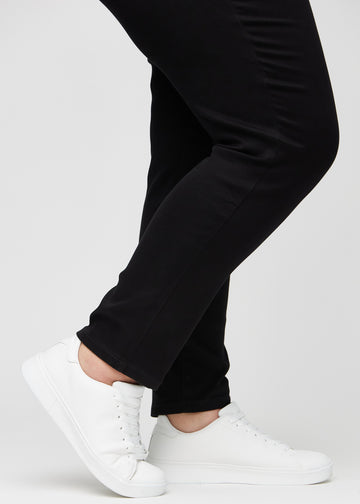 The ankles of a plus-size model, so you can see how closely the jeans fit in a Slim fit.