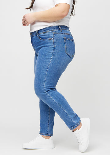 Slim jeans for women in blue, color Rivers. Side view on a plus-size model.