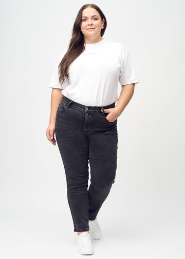 Slim jeans for women in dark grey, color Shadows. Full-length view of a plus-size model wearing the jeans.