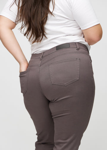 Slim jeans for women in grey-brown, color Thunders. Close-up back view on a plus-size model, showing the details.