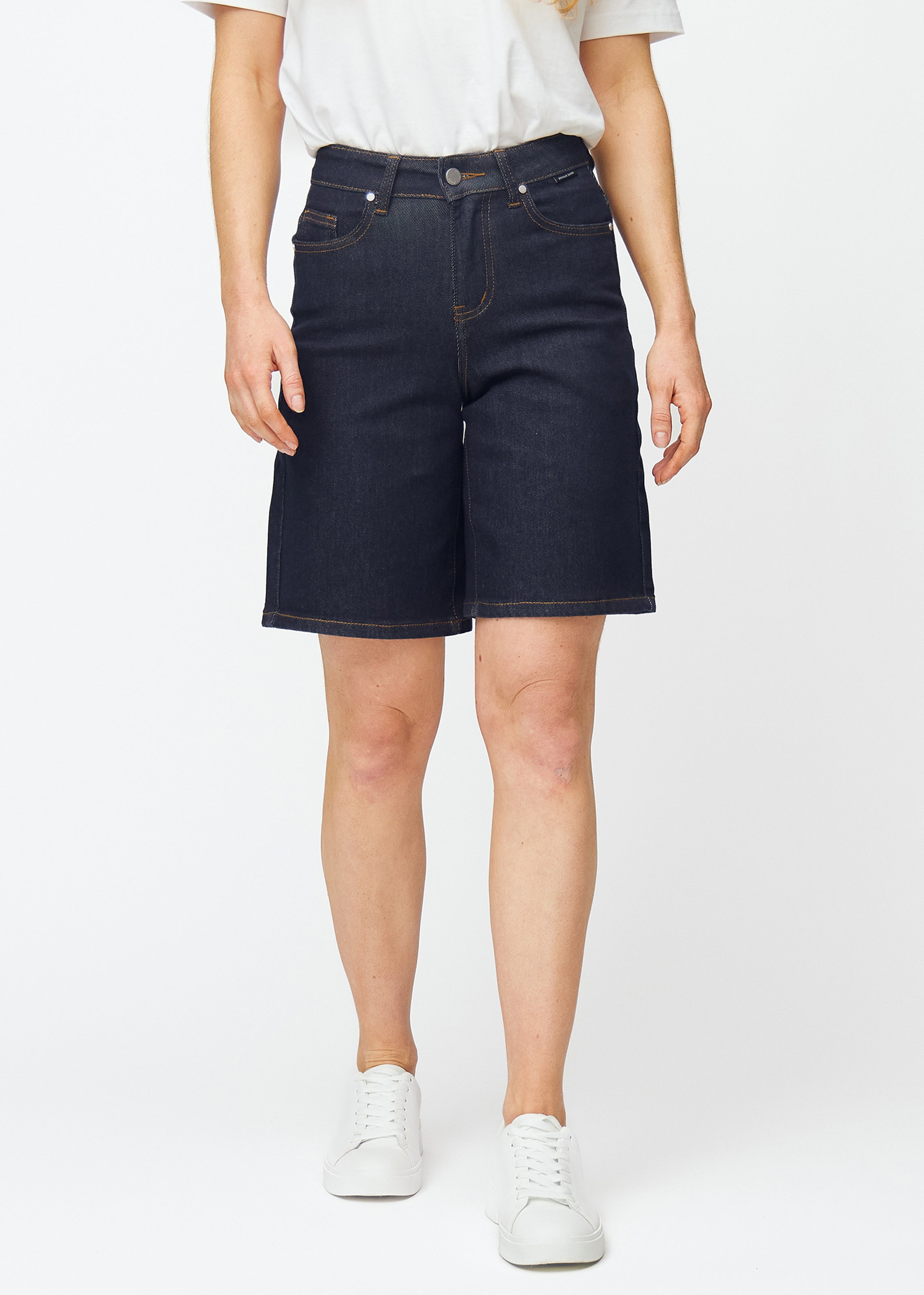 Deep dark blue denim shorts for women in the colour Midnights with a loose fit, sitting at the hips and falling loosely over the thighs, seen from the front.