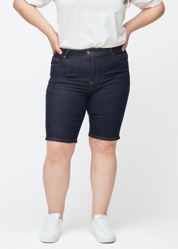 Deep dark blue denim shorts for women in the colour Midnights with a skinny fit seen from the front on a plus-size model.
