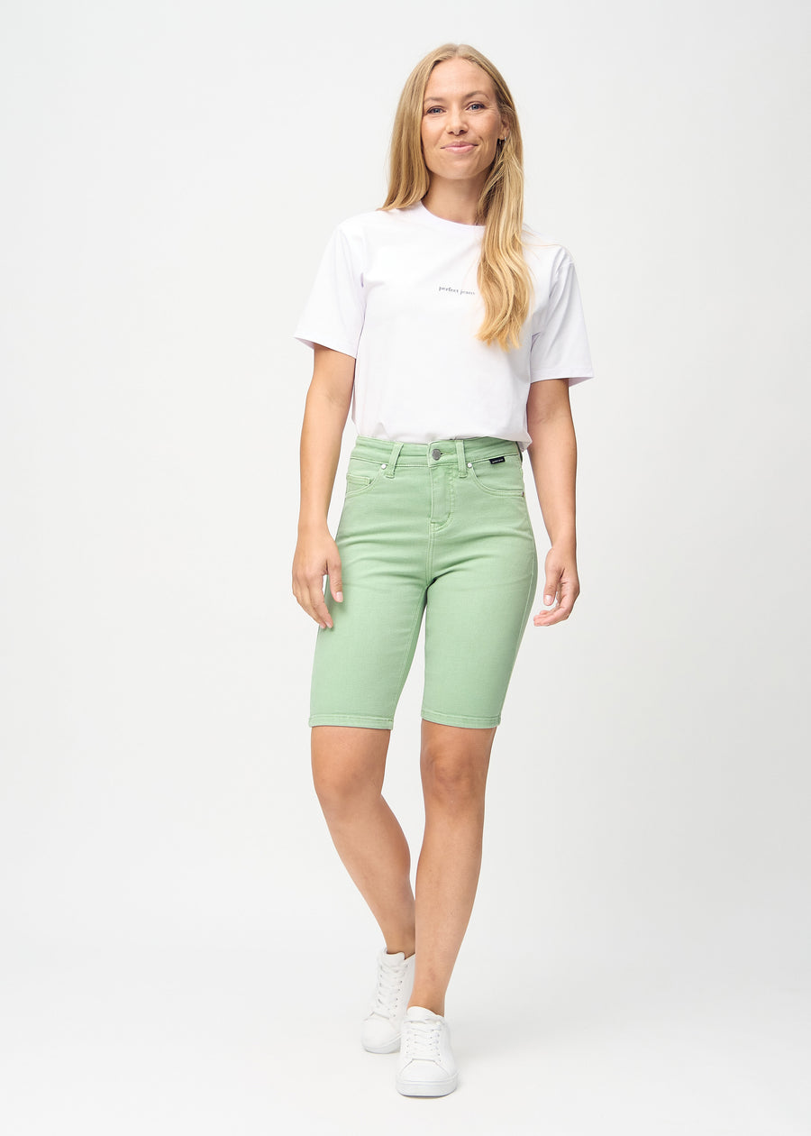 Full image of model in light green skinny middle shorts.