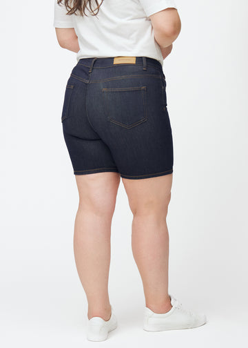 Deep dark blue denim shorts for women in the colour Midnights seen from the back on a plus-size model, showing the length to mid-thigh.