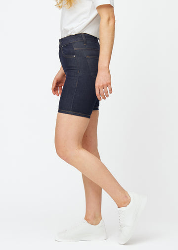 Deep dark blue denim shorts for women in the colour Midnights with a skinny fit seen from the side on a model.