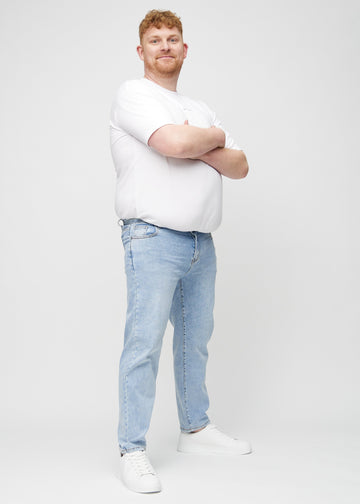 Full image of a plus-size model in light denim regular jeans.