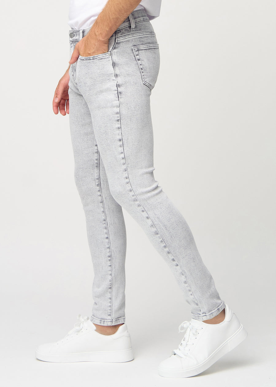 Light grey denim slim jeans viewed from the side on a model.