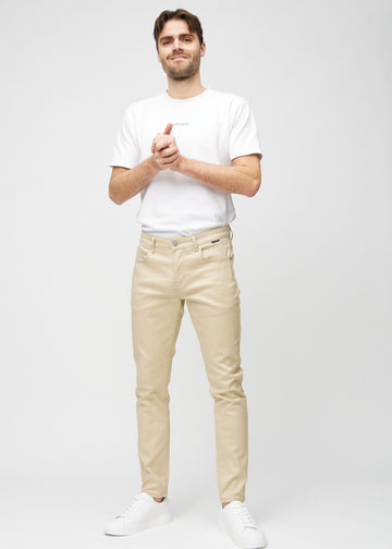 Full-length view of a model in beige slim jeans.
