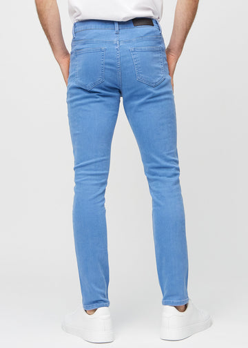 Blue slim jeans viewed from the back to show the full product.